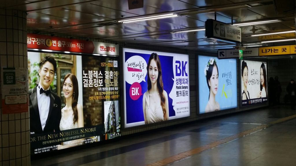 U-Bahnstation Abugegong Station in Seoul mit Werbeanzeigen für Schönheitsoperationen